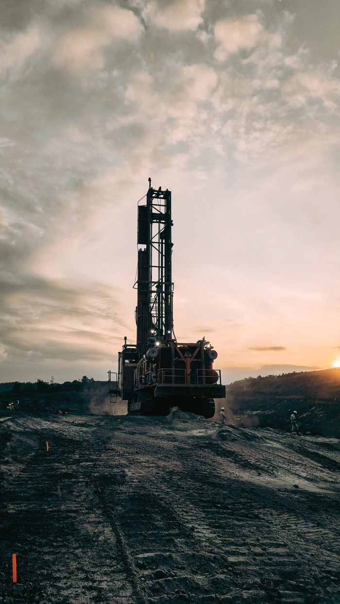 Dramatic scene of mining activities at sunset in Indonesia highlighting industrial machinery.